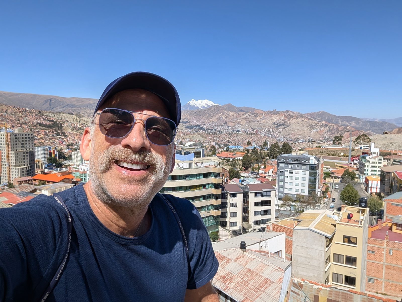 From the roof: the city climbing every hillside, and Illimani (6,438 m) behind.