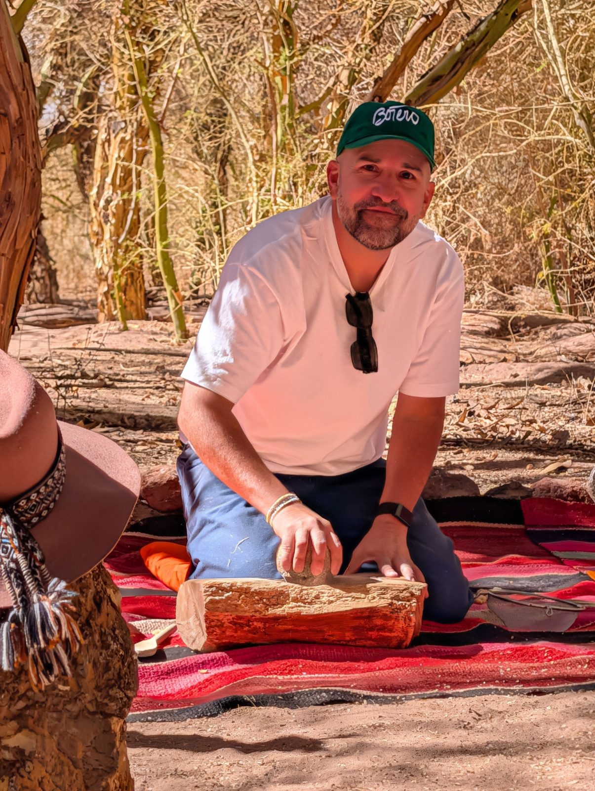 Juan grinding algarrobo with the stone pestle.