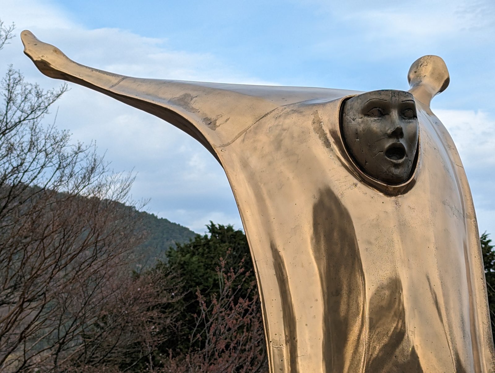 A silver figure with its arms out.