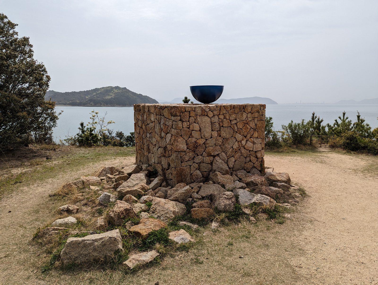 A stone well with a bowl, looking at the Seto Inland Sea.